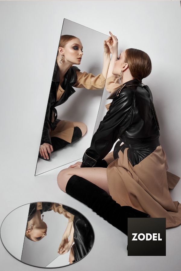 model posing by looking in the mirror to take a picture for her lookbook.