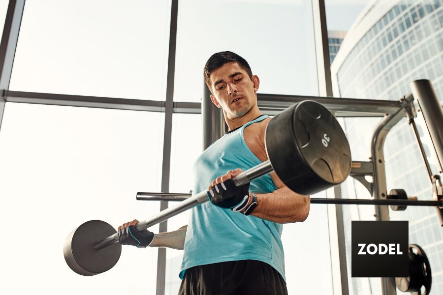 male fitness model lifting barbell during workout.